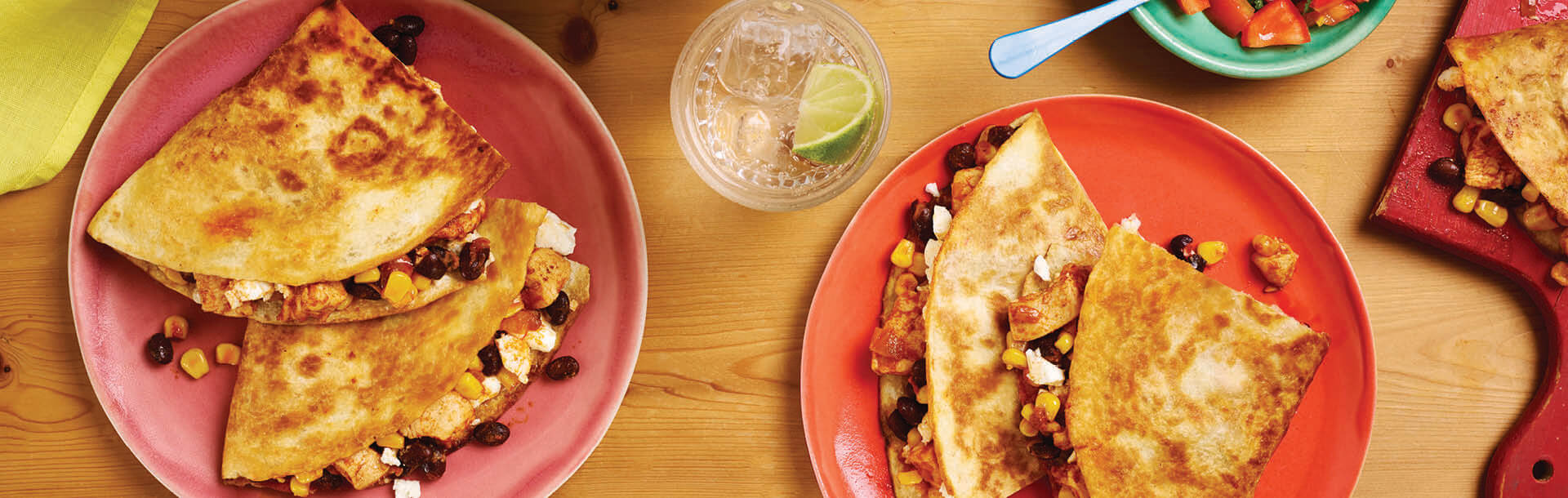 quesadilla servita su piatti rossi su un tavolo di legno